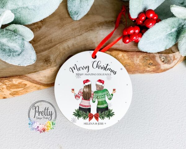 Personalisable christmas Bauble with x2 female characters wearing christmas hats and christmas jumpers