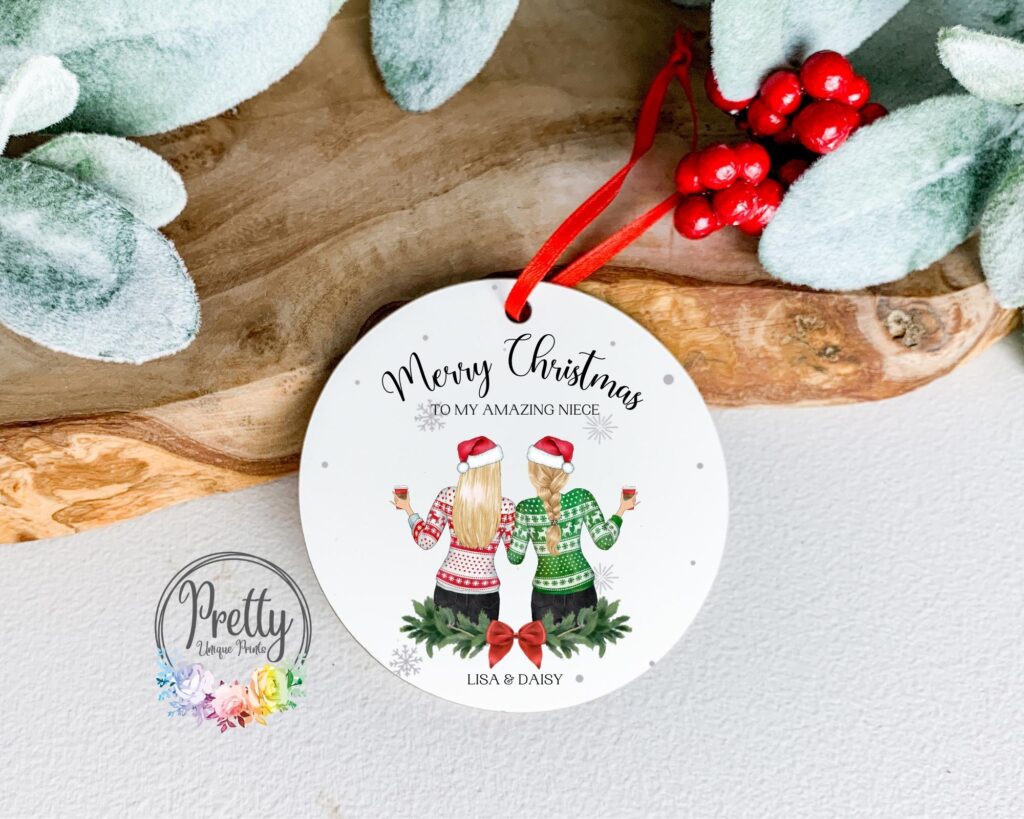 Personalisable christmas Bauble with x2 female characters wearing christmas hats and christmas jumpers